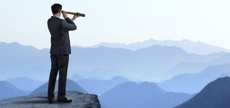 Man looking through telescope out towards horizon